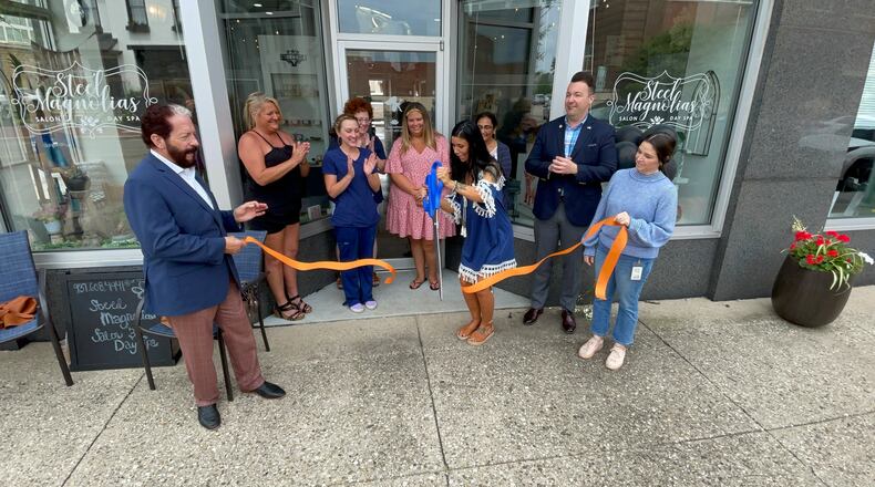 Steel Magnolias Salon and Day Spa owner Allie Greene cuts the ribbon to her new location at 120 N. 2nd St. in downtown Hamilton. MICHAEL D. PITMAN/STAFF