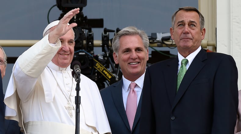 FILE - House Speaker John Boehner of Ohio becomes emotional as Pope Francis appears on the Speaker's Balcony on Capitol Hill, Sept. 24, 2015 and waves to the waiting crowd. The pope addressed a joint meeting of Congress before stepping out on the balcony. Between the pope and Boehner is Majority Leader Kevin McCarthy of California. (AP Photo/Susan Walsh, File)