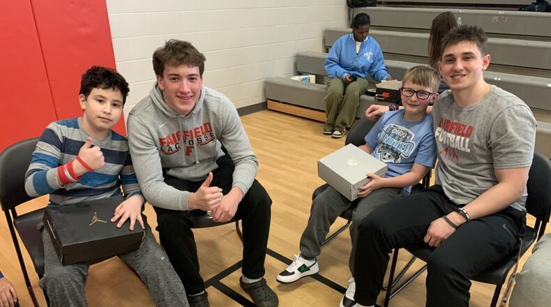Dozens of Central Elementary students were recently surprised by Fairfield High School athletes and a local charity presented them with free shoes in a school ceremony. The 5th graders were escorted into the school’s gym last week and discovered they were the main attraction for a planned celebration by the older Fairfield students, school teachers and staffers who cheered on their red-carpet entrance before presenting them with new athletic shoes. Pictured are two Fairfield High School athletes with Central students. (Provided)