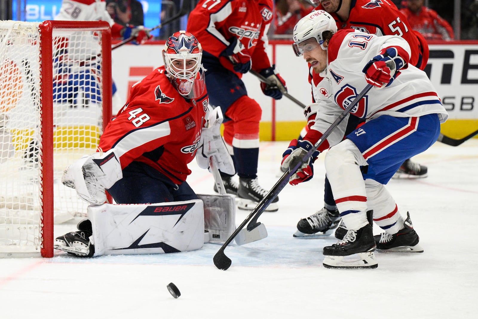 Washington Capitals goaltender Logan Thompson (48) and Montreal Canadiens right wing Brendan Gallagher (11) look for the puck in the second period of Game 5 of a first-round NHL hockey playoff series Wednesday, April 30, 2025, in Washington. (AP Photo/Nick Wass)