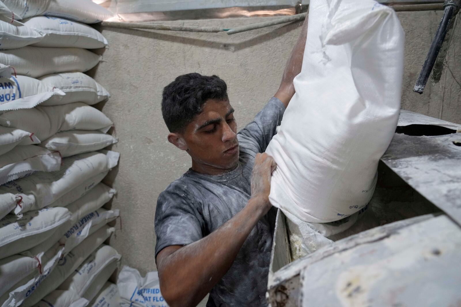 Palestinians bake bread after the World Food Program was able to bring in flour for the first time in over a month as Israel allowed some aid to enter the Gaza Strip, in Deir al-Balah, Gaza Strip, Thursday, May 22, 2025. (AP Photo/Abdel Kareem Hana)