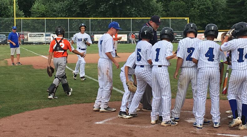 Hamilton West Side’s Ethan Stone is about to receive congratulations from his teammates, along with Galion catcher Chase Studer, after a second-inning home run Thursday night in the Ohio Little League Tournament at the Hoover Community Recreation Complex in North Canton. Hamilton won 15-1. RICK CASSANO/STAFF