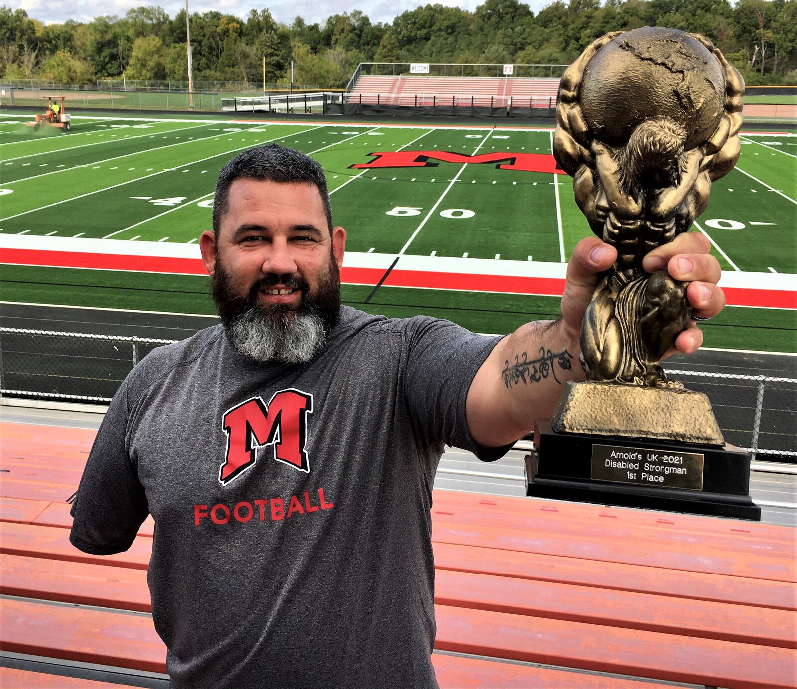 Former area fireman Mike Diehl - now an assistant coach with Madison High School football - lost his right arm in a 2015 fire truck accident, Diehl, a 41-year-old father of two, just came back from London, England as that world competition's first place disabled strong man award. Diehl says part of his motivation is to inspire the youth he coaches. (Photo By Michael D. Clark\Journal-News)