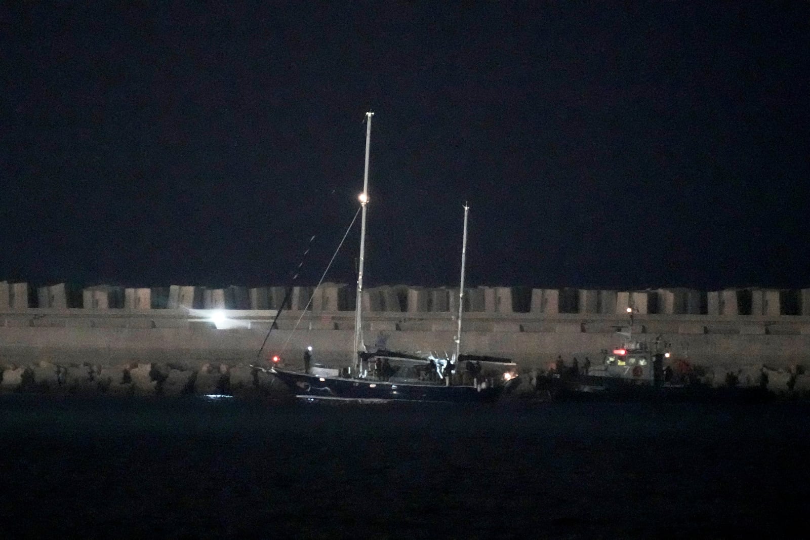 The Gaza-bound aid boat, Madleen, under escort of Israeli naval forces enters to Ashdod Port in southern Israel after being seized by Israeli forces, Monday, June 9, 2025. (AP Photo/Leo Correa)