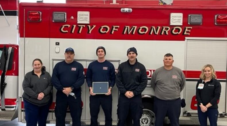 Members of the Monroe Fire Department received the first Challenge Coins from Atrium Medical Center, part of Premier Health. They were recognized for going 'above and beyond' when they used a treatment technique that may have saved a gunshot victim's life. From left, Ann Brock, trauma outreach coordinator at Atrium, firefighters Joel Coomer, Jacob Zeckser, Todd Lohse, Lt Rusty Rickard and Claire Hardman, trauma program manager at Atrium. They removed their masks for the picture, then put them back on. CONTRIBUTED