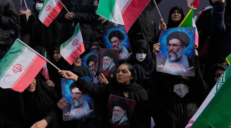 People wave Iranian flags as they hold posters of the late Supreme Leader Ayatollah Ali Khamenei, showing him at different ages, during a rally to support his son Ayatollah Mojtaba Khamenei, who succeeds his father as the new supreme leader, in Tehran, Iran, Monday, March 9, 2026. (AP Photo/Vahid Salemi)