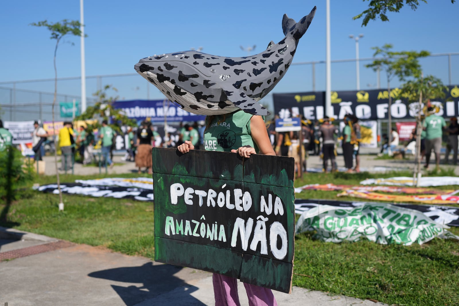 An protester wearing a whale mask holds a sign that reads in Portuguese, "No oil in the Amazon" to demonstrate against the auction of dozens of oil blocks, including blocks near the mouth of the Amazon River, in Rio de Janeiro, Tuesday, June 17, 2025. (AP Photo/Silvia Izquierdo