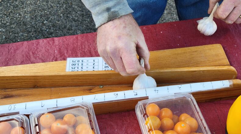 Buying white garlic at the Oxford Farmers Market from the Harkrider family’s Stoney Hedgerow Farm is especially entertaining. Select a bulb and place it in a wooden trapezoidal-shaped device that measures its diameter on a scale from 1 to 10. The scale number determines the price. CONTRIBUTED