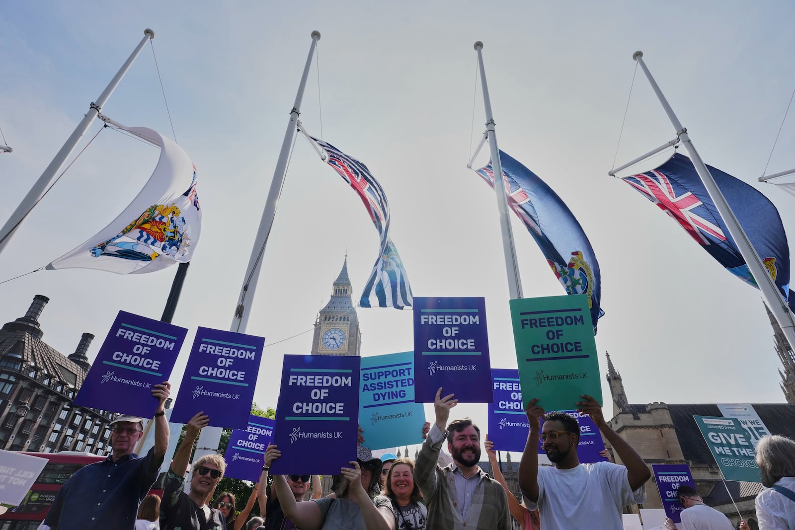 Demonstrators for assisted dying hold banners outside Parliament in London, Friday, June 20, 2025, as British lawmakers are set to vote Friday on whether to back a bill to help terminally ill adults end their lives in England and Wales. (AP Photo/Kirsty Wigglesworth)