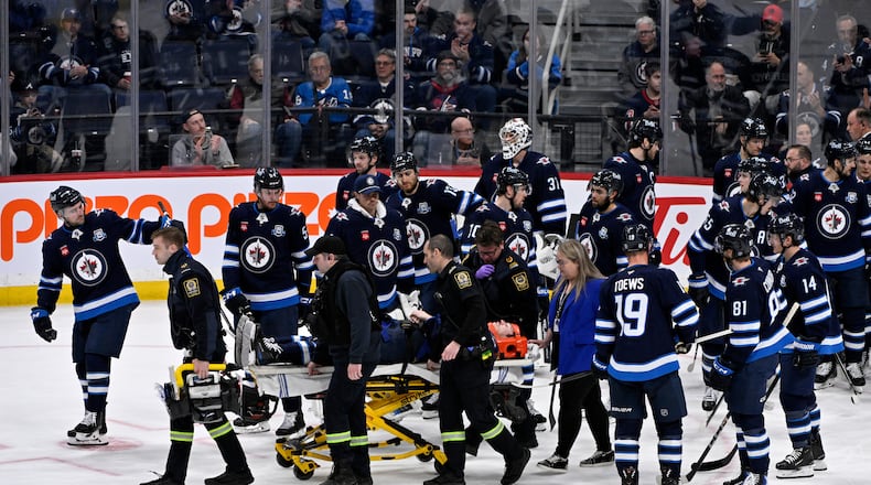 Winnipeg Jets' Haydn Fleury is helped off the ice after being injured against the Vegas Golden Knights during the first period of their NHL hockey game in Winnipeg, Tuesday Jan. 6, 2026. (Fred Greenslade/The Canadian Press via AP)