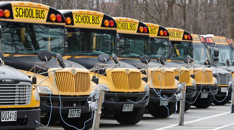 FILE - A row of school buses rests in a parking lot, April 7, 2020, in Cleveland Heights, Ohio. About 7 in 10 AAPI adults approve of K-12 public schools teaching about the history of slavery, racism and segregation, according to a new poll from AAPI Data and The Associated Press-NORC Center for Public Affairs Research. A similar share also support teaching about the history of Asian American and Pacific Islander communities in the United States, while about half support teaching about issues related to sex and sexuality. (AP Photo/Tony Dejak, File)