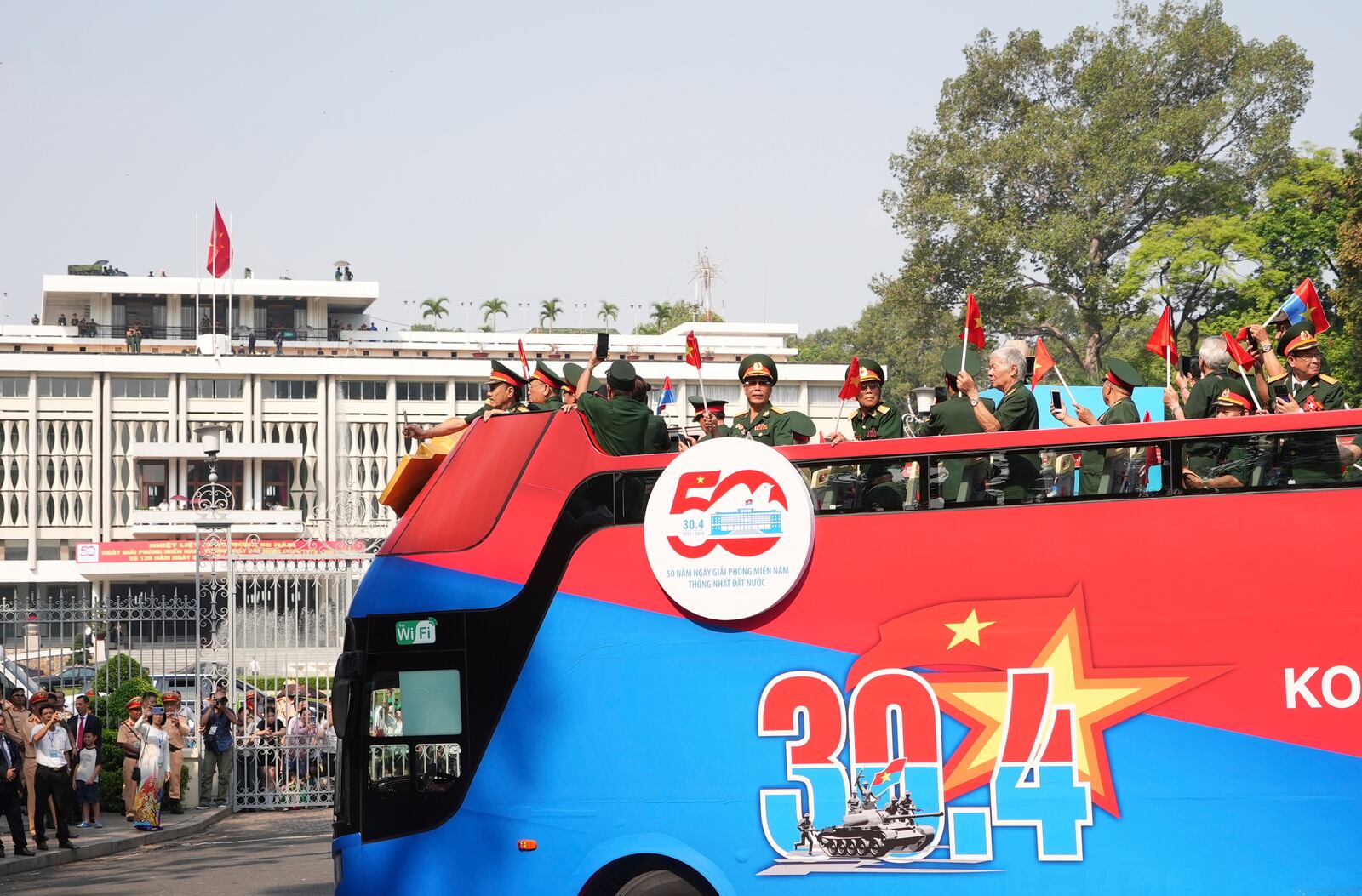 Vietnam War veterans on an open bus pass the Independence Palace during a parade to commemorate the 50th anniversary of the end of the Vietnam War in Ho Chi Minh City Wednesday, April 30, 2025. (AP Photo/Hau Dinh)