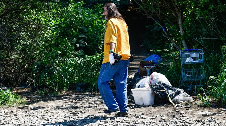 Doug Miller, who lives in the homeless camp beside the CSX railroad tracks behind the Hamilton Plaza shopping center, walks back to the camp after Hamilton Police and railroad police told residents they can no longer cross the tracks. NICK GRAHAM/STAFF