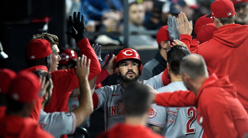 Cincinnati Reds' Eugenio Suarez (7) celebrates with teammates in the dugout after hitting a solo home run during the fifth inning of a baseball game against the Chicago White Sox, Tuesday, Sept. 28, 2021, in Chicago. (AP Photo/Paul Beaty)