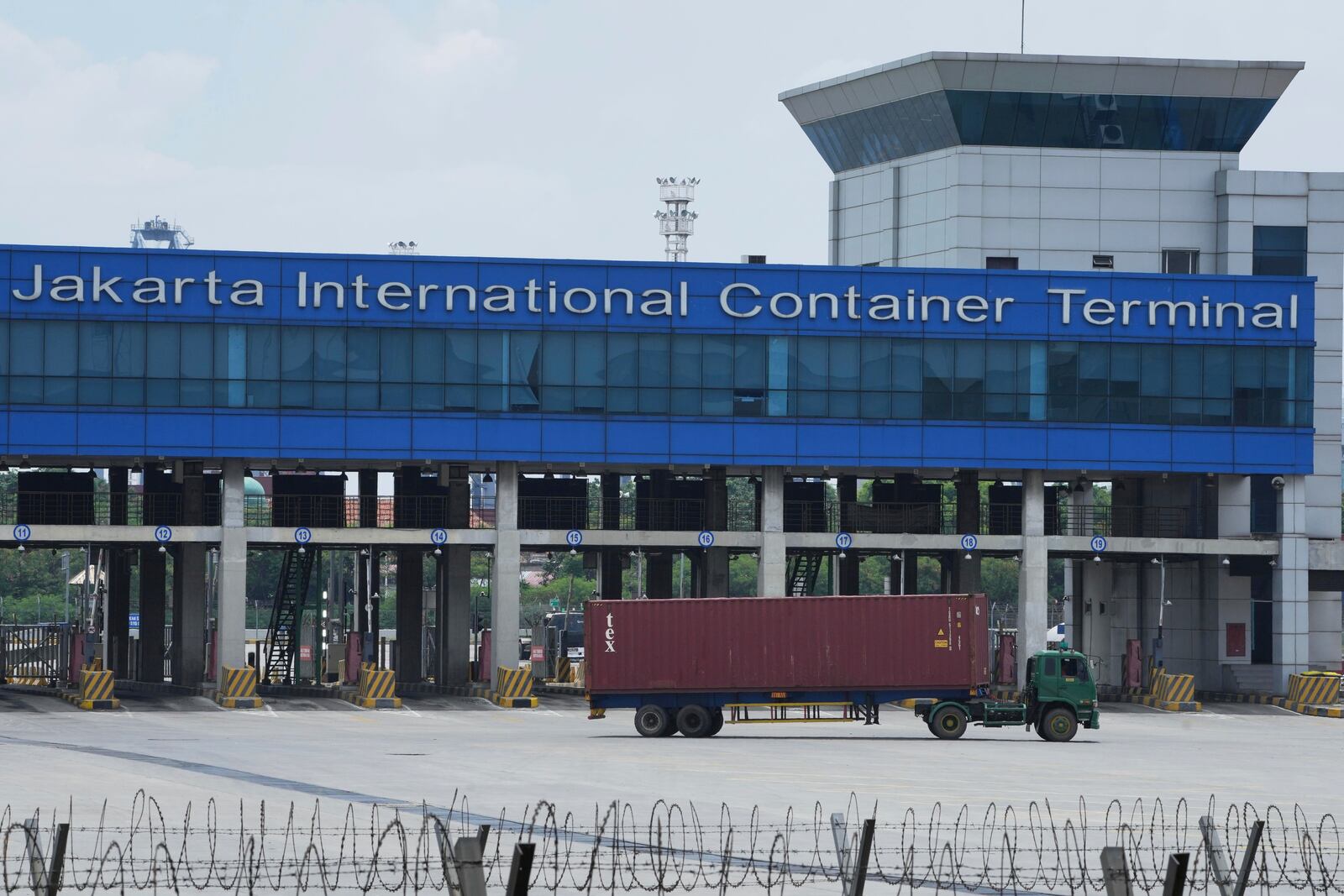 A truck container drives past the Jakarta International container terminal at Tanjung Priok seaport in Jakarta, Indonesia, Thursday, April 3, 2025. (AP Photo/Achmad Ibrahim)