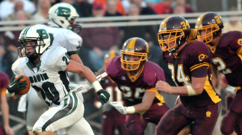 Badin wide receiver Alex Rieman gets past Ross defenders Brennan McGuire, Cody Lotton and Logan Hannon en route to a touchdown Sept. 10, 2010, at Robinson Field in Ross. Badin won the game 31-13. JOURNAL-NEWS FILE PHOTO