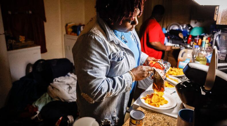 Ira Butler makes dinner for her four children in her Harrison Twp. home. Butler lost her fiance in August to COVID-19 and is now raising their children alone. JIM NOELKER/STAFF