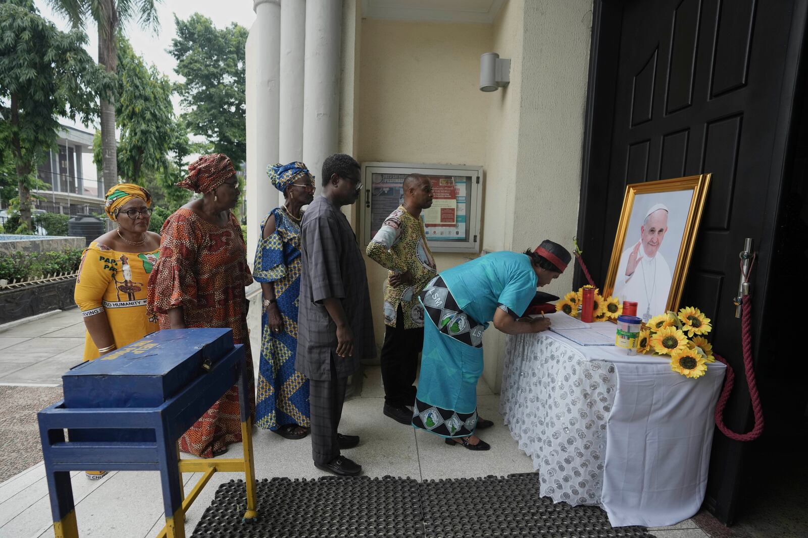 Parishioner sign a condolence register book in honour of the late Pope Francis at the Holy Cross Cathedral Church in Lagos, Nigeria, Wednesday, April 23, 2025, (AP Photo/Sunday Alamba)