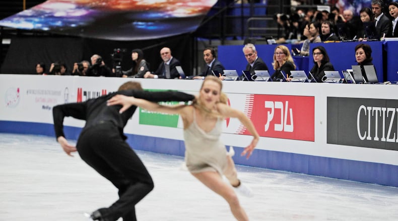 FILE - Judges watch Russia's Victoria Sinitsina and Nikita Katsalapov perform their ice dance free dance during the ISU World Figure Skating Championships at Saitama Super Arena in Saitama, north of Tokyo, March 23, 2019. (AP Photo/Andy Wong, File)