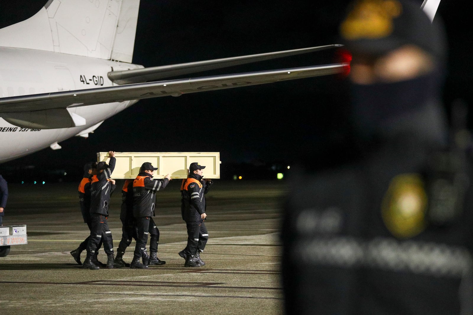 FILE - Workers carry a coffin with the body of a victim from the Azerbaijani Airlines crash near the Kazakhstani city of Aktau, at the Heydar Aliyev International Airport outside Baku, Azerbaijan, Dec. 28, 2024. (AP Photo, File)