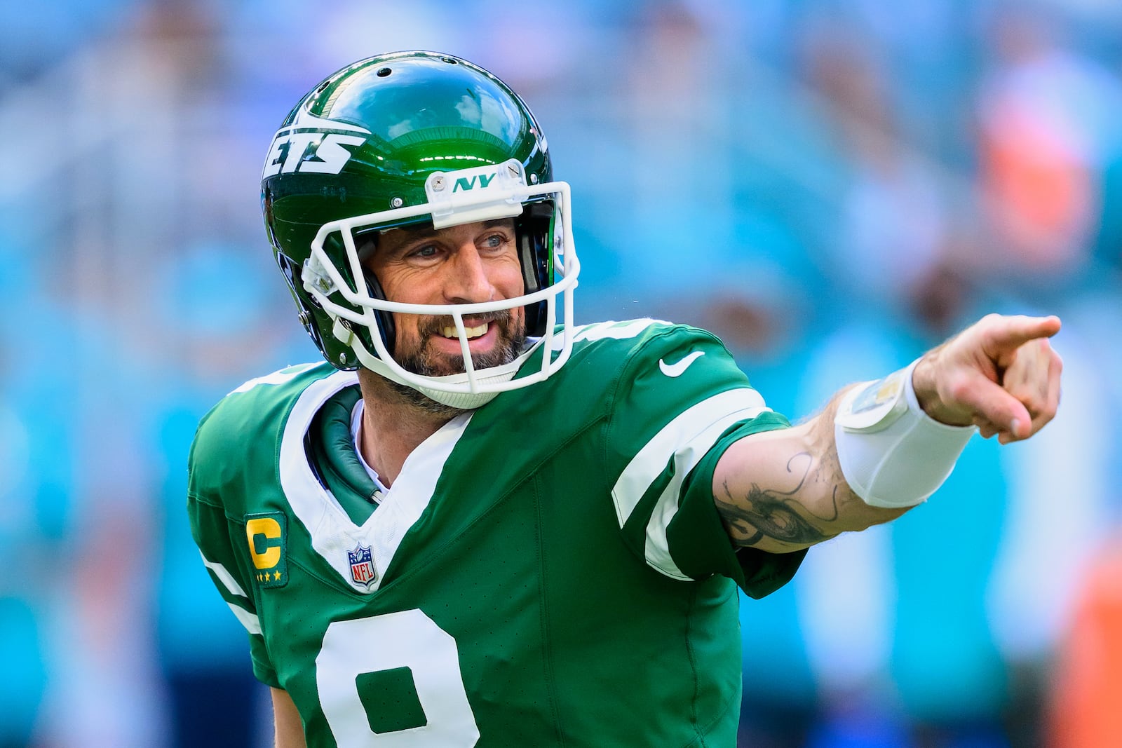 FILE - New York Jets quarterback Aaron Rodgers (8) smiles and points during an NFL football game against the Miami Dolphins, Sunday, Dec. 8, 2024, in Miami Gardens, Fla. (AP Photo/Doug Murray, File)