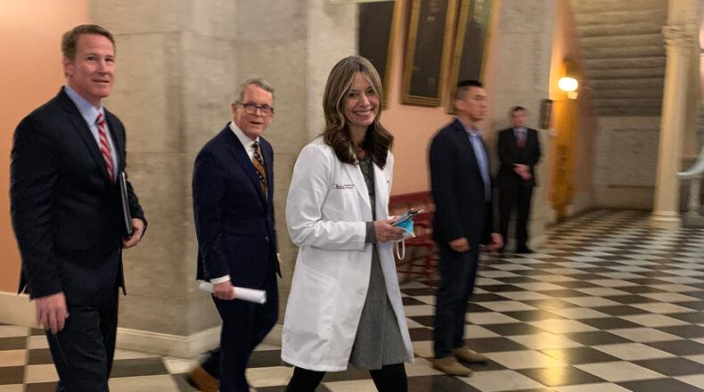 Ohio Gov. Mike DeWine (center) walks with Health Director Dr. Amy Acton (right) and Lt. Gov. Jon Husted (left) after Wednesday's press conference at the Statehouse. LAURA A. BISCHOFF/STAFF