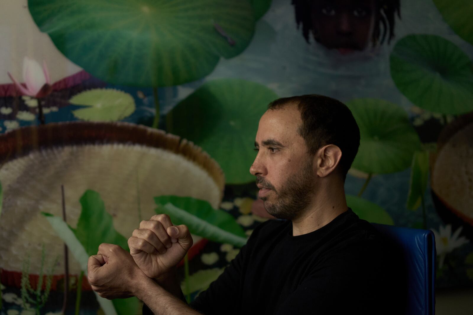 Freed Israeli hostage Tal Shoham, who was held by Hamas militants in the Gaza Strip, demonstrates how his captors handcuffed him, in Tel Aviv, Israel, Tuesday, April 22, 2025. (AP Photo/Maya Alleruzzo)