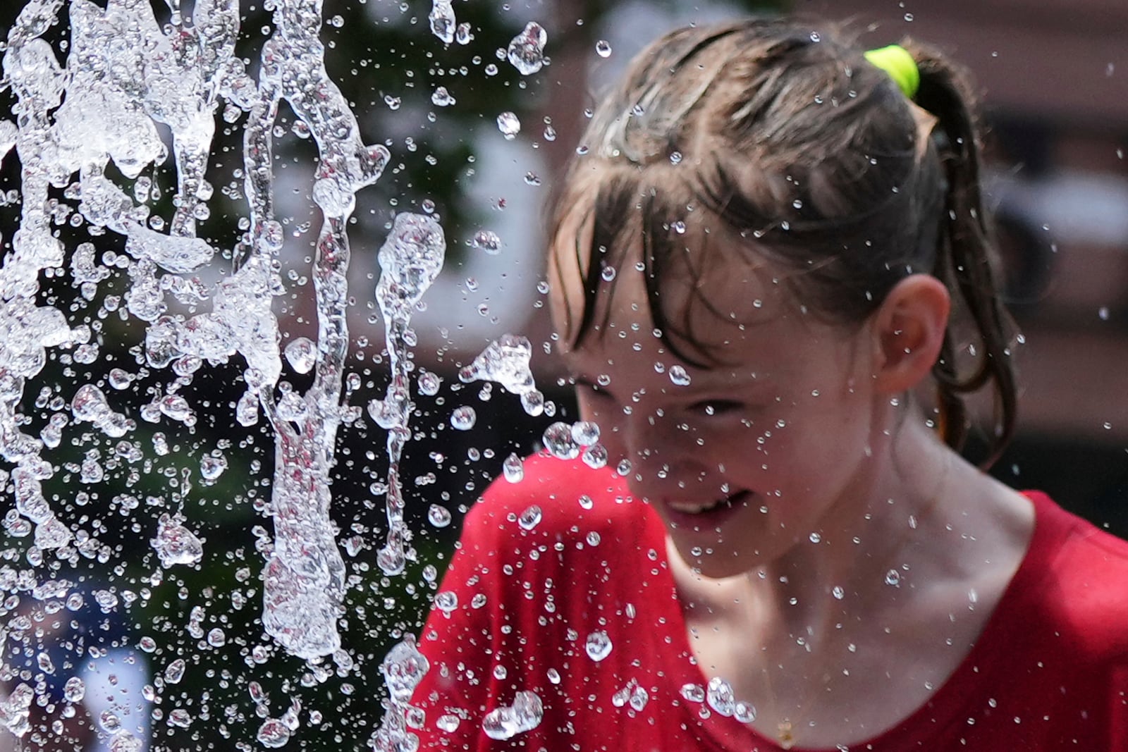 Bay Puro cools off at a fountain during hot weather in Chicago, Sunday, June 22, 2025. (AP Photo/Nam Y. Huh)