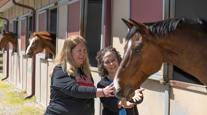 And for the first time this spring semester, Miami University's Student Counseling Service is having participating students working with horses via Miami’s Equestrian Center, located on the Oxford campus’ eastern border, said school officials. Pictured are Heather Pinnick, director of the equestrian center, (left) and Jennifer Young, a licensed psychologist and associate director for community engagement in the Student Counseling Service. (Provided)
