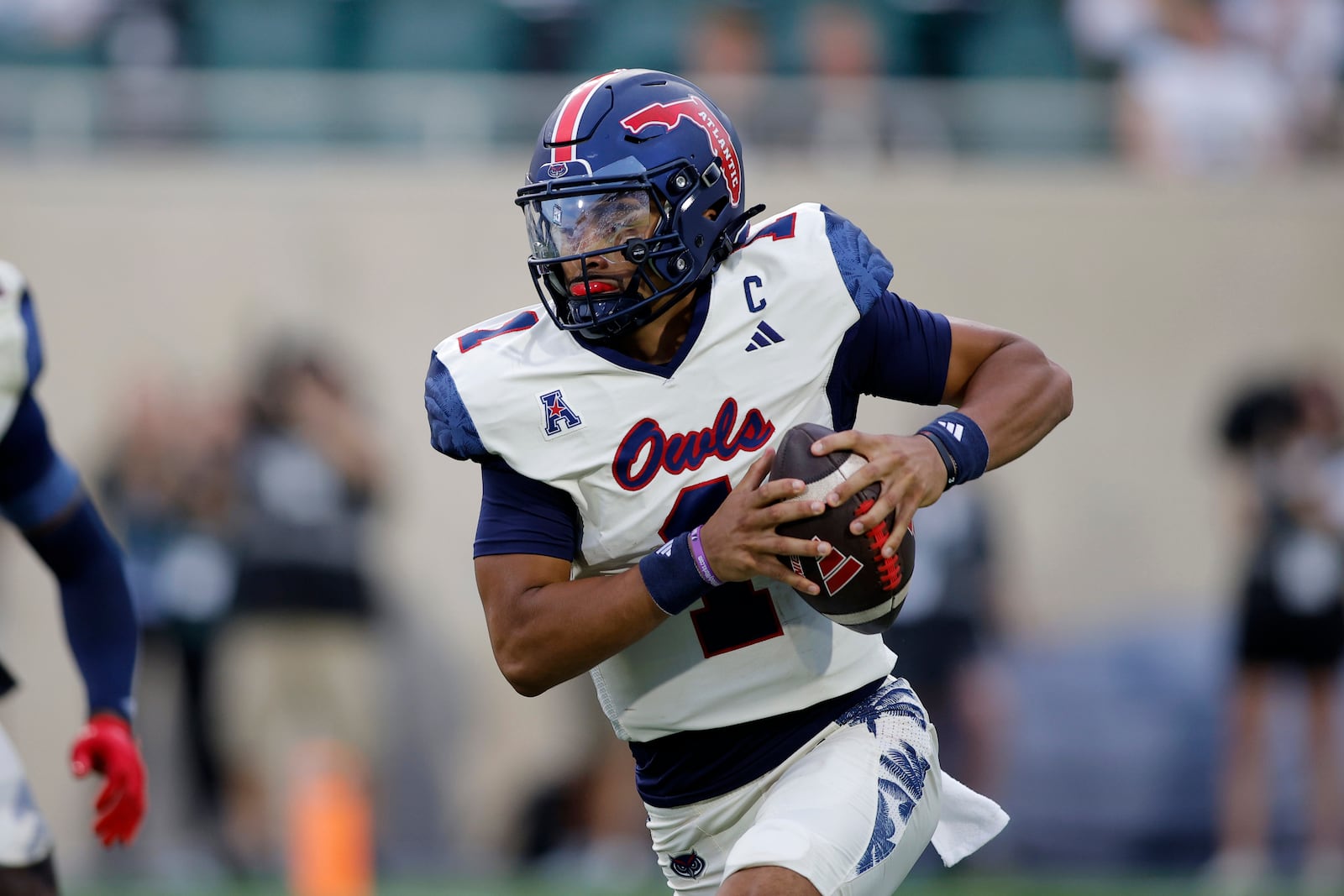 Florida Atlantic quarterback Cam Fancher runs on a keeper against Michigan State during the first quarter of an NCAA college football game, Friday, Aug. 30, 2024, in East Lansing, Mich. (AP Photo/Al Goldis)