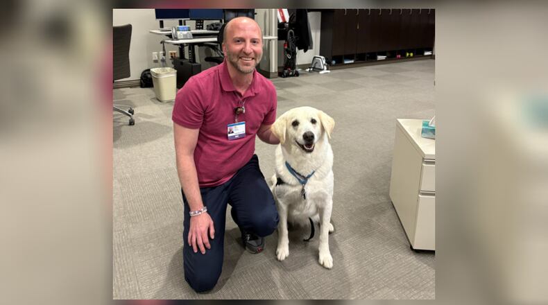 Kettering Health Operations Command Center Nursing Supervisor Nik Saxon visits with Nick from the Miami Valley Pet Therapy Association. CONTRIBUTED
