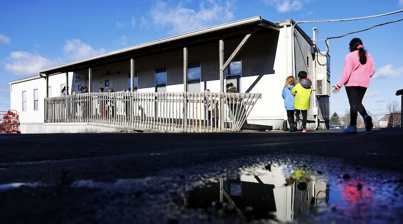 Students make their way to a portable classroom building at Lakota's Cherokee Elementary School in Liberty Township. The school is among those in the district experiencing overcrowding as Lakota has seen an increase in recent years to its enrollment, which now is about 17,200 students. The Lakota school board will vote on a new master facilities plan at its Monday meeting. NICK GRAHAM/STAFF