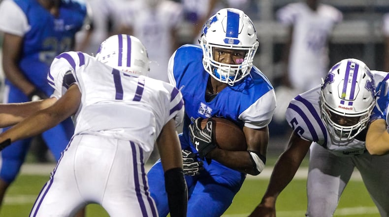 Hamilton’s Kaleb Johnson carries the ball between two Middletown defenders, including Kenny Wilson (17), during Friday night’s game at Virgil Schwarm Stadium in Hamilton. Host Big Blue won 15-14. NICK GRAHAM/STAFF