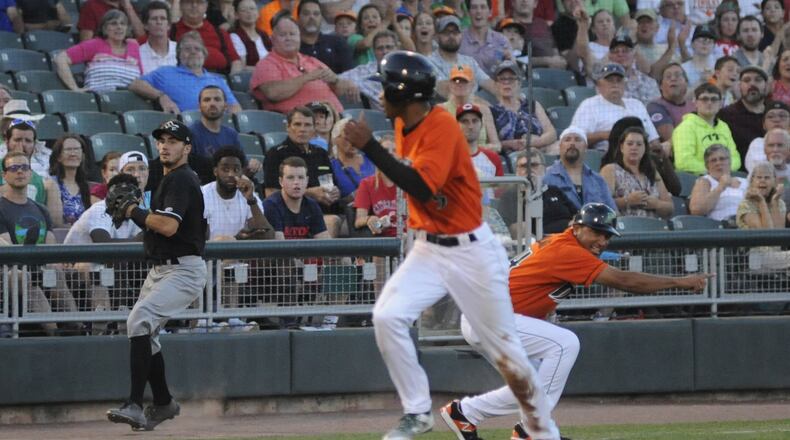 Andy Sugilio of the Dragons runs through manager Luis Bolivar’s call to return to third base. Sugilio was tagged out in a rundown. Dayton defeated Quad Cities 6-5 in 10 innings at Fifth Third Field on Friday, July 13, 2018. MARC PENDLETON / STAFF