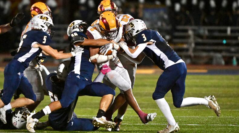 Ross running back Riley Caldwell is tackled by a host of Monroe defenders on Friday.AJ Fullam/CONTRIBUTED