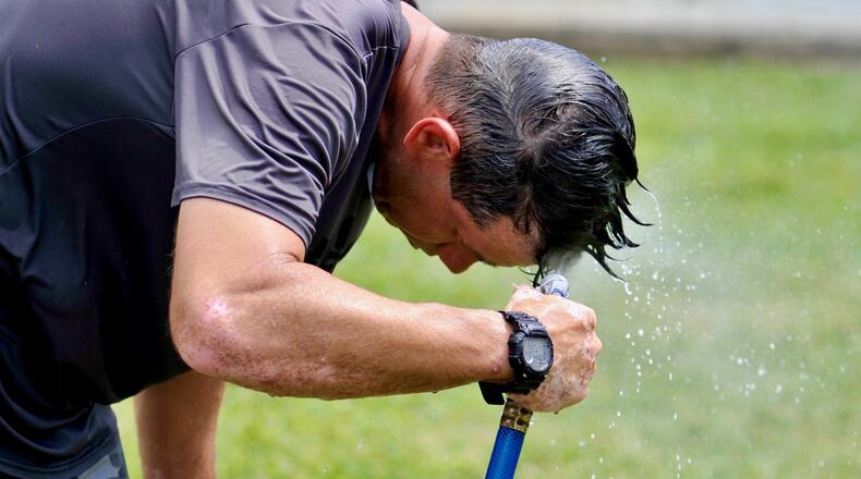 Michael Fernandez with Triple Threat Shows cooling of as he sets up games on a hot Thursday afternoon.