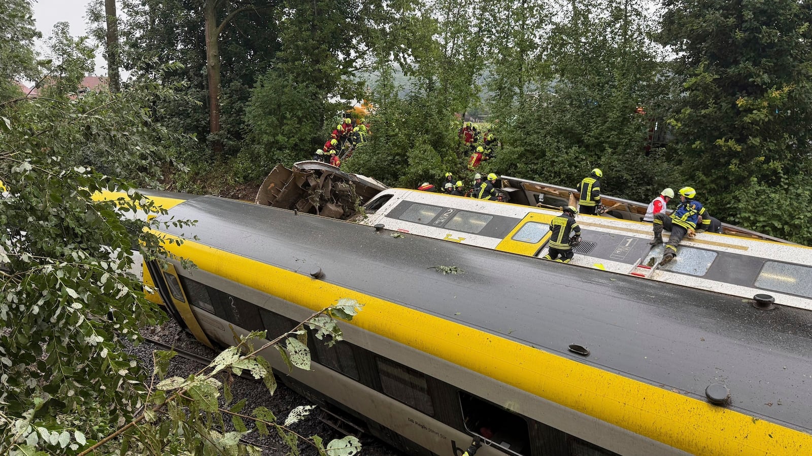 Rescue workers search for passengers in a derailed train, Zwiefaltendorf, Sunday July 27, 2025. (Thomas Warnack/dpa via AP)