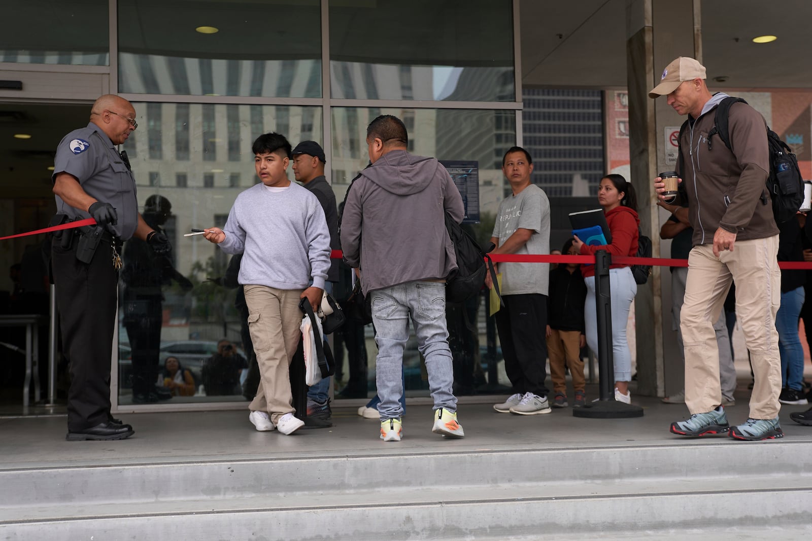 People line up outside the Los Angeles Federal Building in Los Angeles, housing the U.S. Immigration and Customs Enforcement (ICE) and U.S. Citizenship and Immigration Services (USCIS) on Wednesday, June 25, 2025. (AP Photo/Damian Dovarganes)