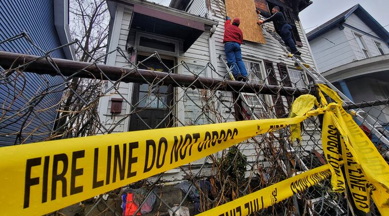 A crew works to board up a house in the 400 block of East Avenue after a fire in the early morning hours Tuesday, Dec. 28, 2021 in Hamilton. NICK GRAHAM / STAFF
