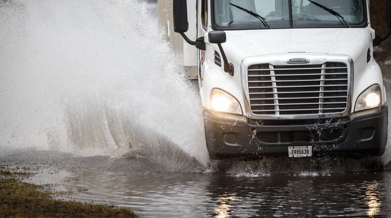 A truck drives through high water caused by heavy rain Tuesday, Feb. 22, 2022, on Nicholas Road in Dayton. MARSHALL GORBY/STAFF