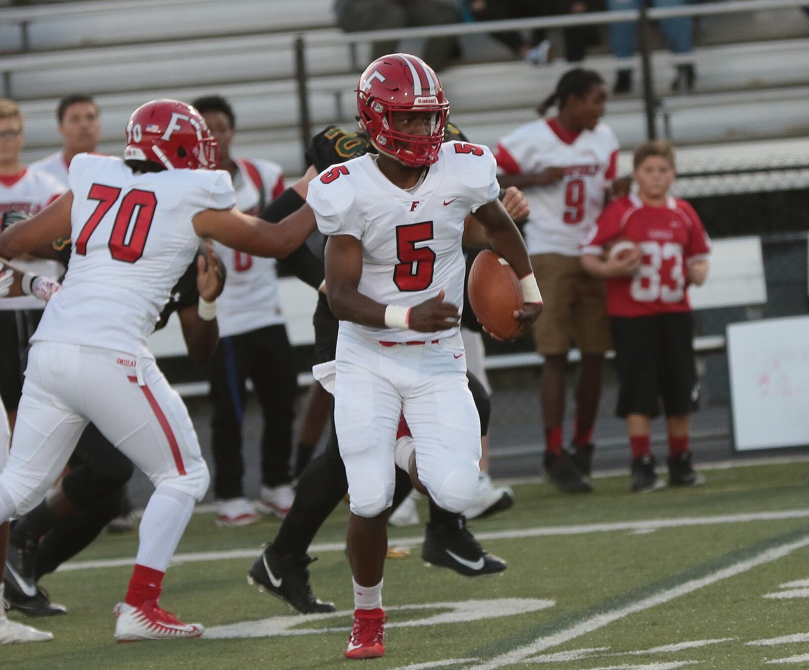 Fairfield quarterback Jeff Tyus (5) gets a block from Isaiah Coleman (70) and heads into open territory during Thursday night’s game at Coach Bud Acus Alumni Field at Sycamore Stadium. CONTRIBUTED PHOTO BY TONY TRIBBLE/WCPO.COM