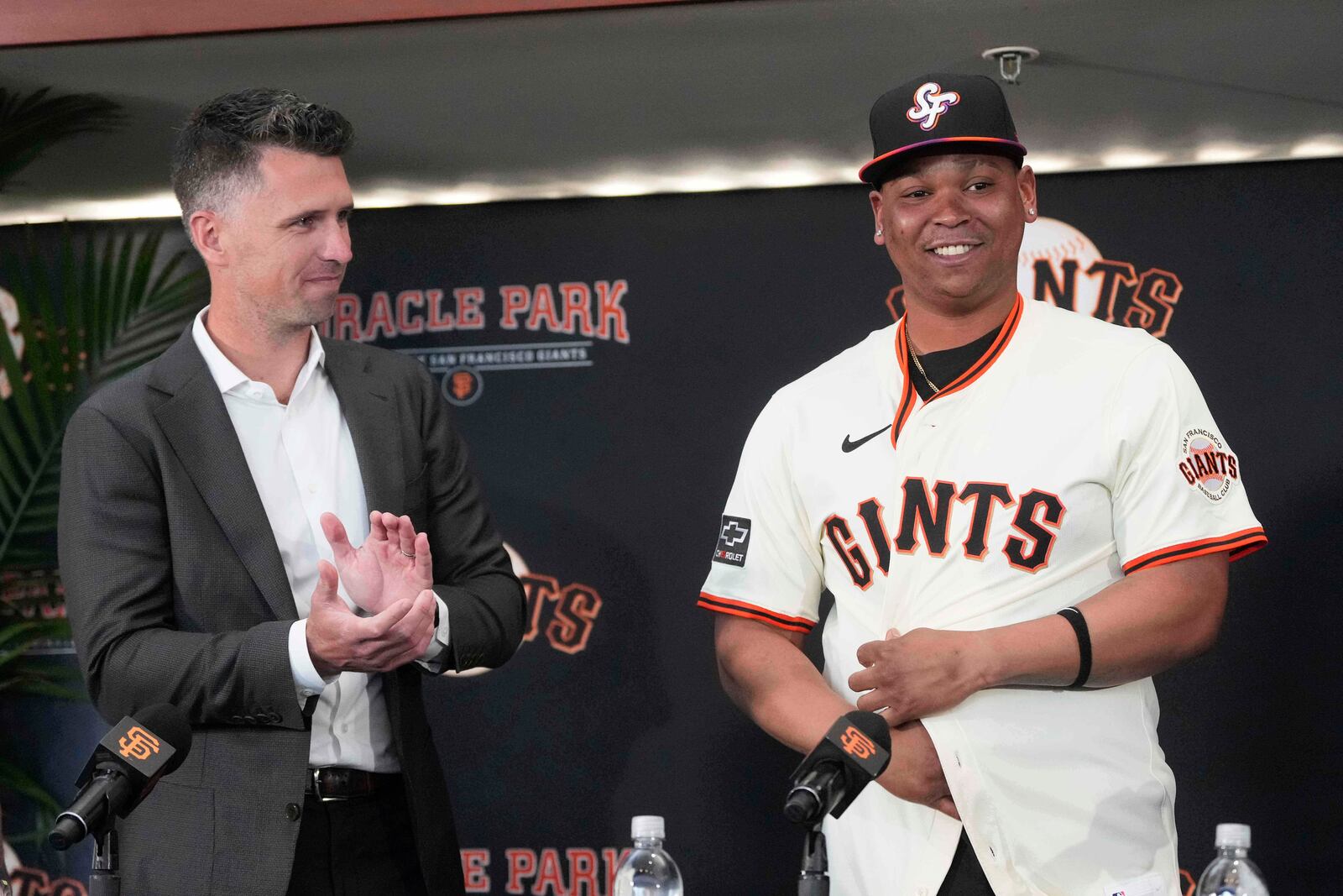 San Francisco Giants' Rafael Devers, right, smiles next to President of Baseball Operations Buster Posey at a news conference before a baseball game between the Giants and the Cleveland Guardians in San Francisco, Tuesday, June 17, 2025. (AP Photo/Jeff Chiu)