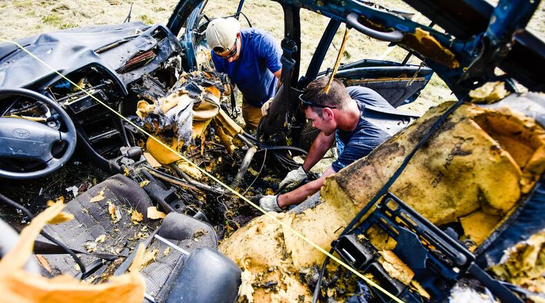 The Butler County Sheriff’s Office bomb unit hosted a training this week with over ten other agencies participating at their bomb range on Woodsdale Road in Madison Township. The training included classroom time and and explosive devices were detonated in four cars to give participants the opportunity to get real world experience searching for the cause of the explosions. Sr. Airman Alex Basabe, left, from Hill Air Force Base in Utah, and A1C Johnathon Jones, with explosive ordinance disposal at Wright Patterson Air Force Base, search through evidence to find the cause of the blast. NICK GRAHAM/STAFF
