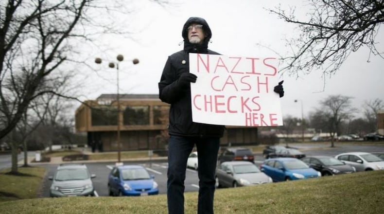 A protester alerts passersby to the office building in Worthington, Ohio, where, until recently, white supremacist Andrew Anglin was having donations to his cause sent. Now, the donations to his Daily Stormer site go to a Worthington post office box. MADDIE MCGARVEY / COLUMBUS ALIVE
