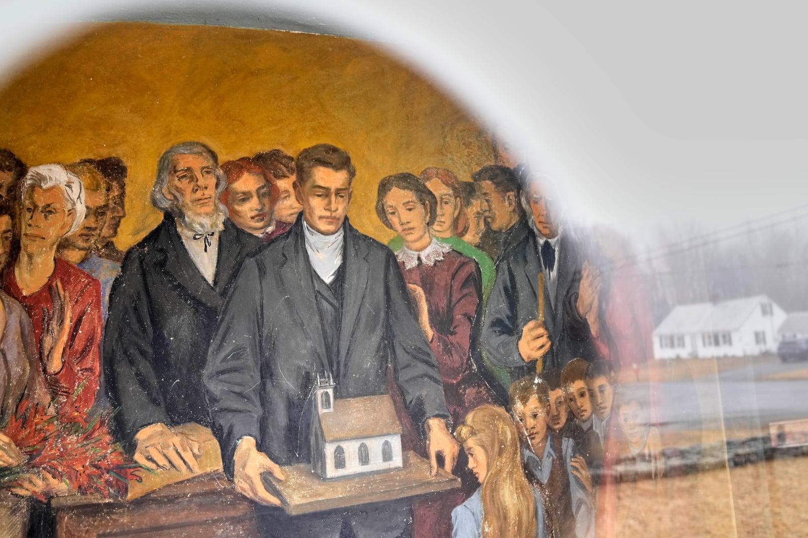 A fresco depicting community members with a model of South Solon Meeting House, is seen through a window in the lobby of the building, Sunday, April 6, 2025, in Solon, Maine. (AP Photo/Robert F. Bukaty)