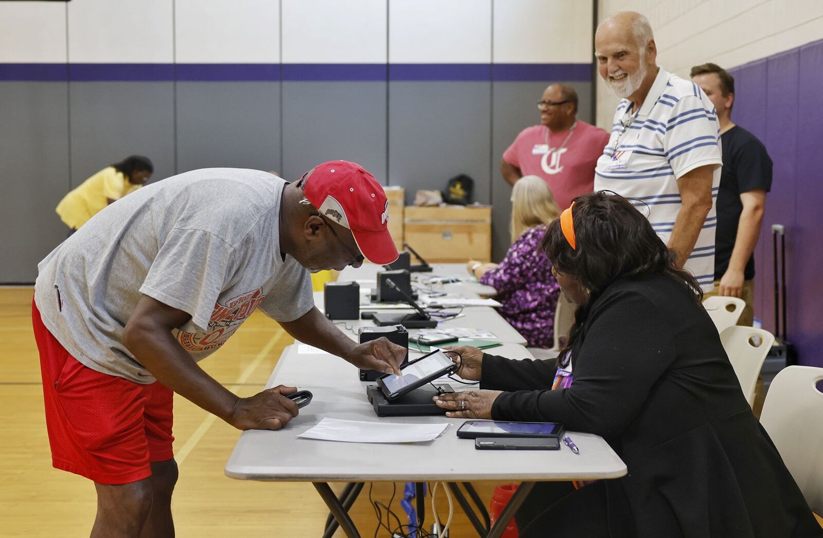 Election official Diana Smiley, right, helps Randall Patterson get checked in to vote Tuesday, Aug. 8, 2023 at Rosa Parks Elementary School in Middletown. NICK GRAHAM/STAFF