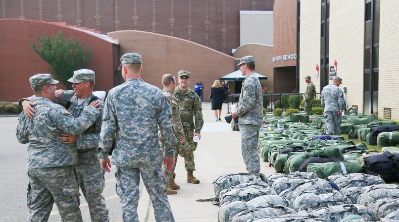 Sgt. Ryan Webb of Morrow, center, says goodbye to fellow soldiers Colton Palmer and Daniel Kloppenburg after returning from deployment, Thursday, Aug. 4, 2016. More than 100 members of the Middletown-based Ohio Army National Guard's 324th Military Police Co. returned to a Welcoming Ceremony at Franklin High School after an 11-month deployment guarding prisoners at Guantanamo Bay, Cuba. GREG LYNCH / STAFF