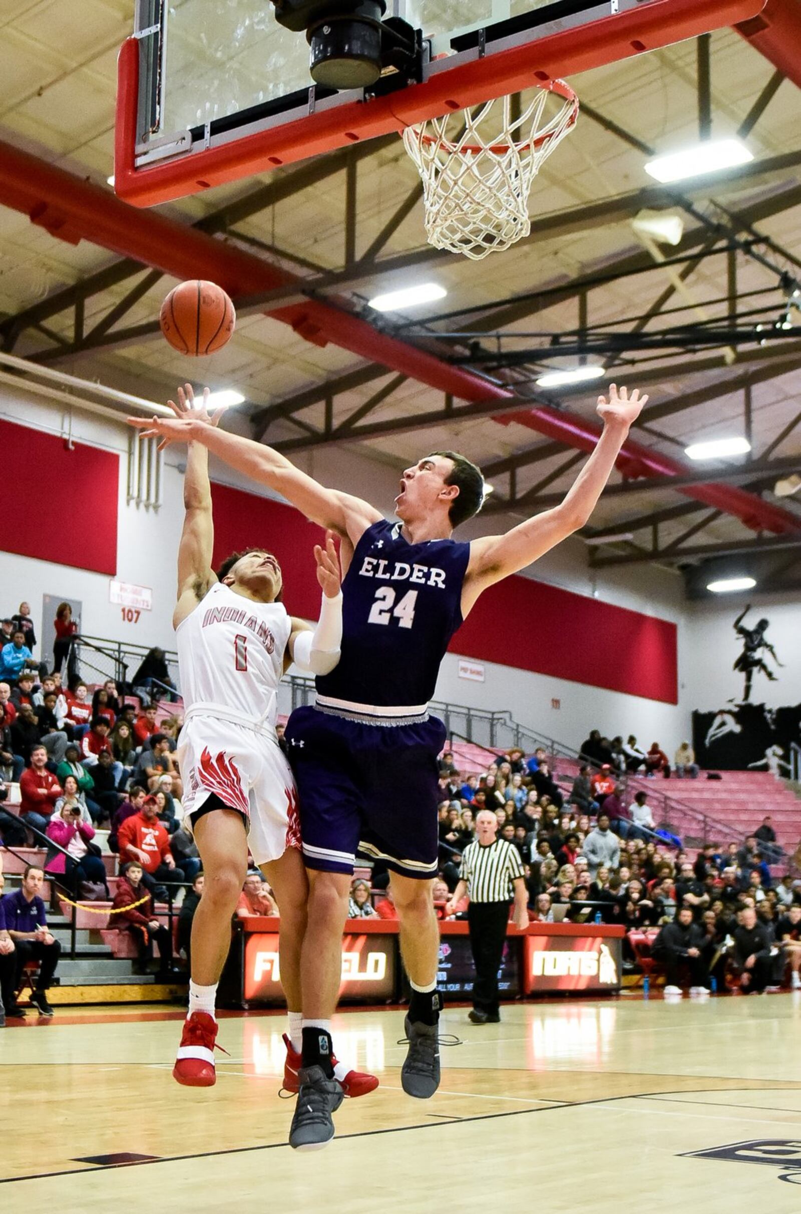 Fairfield’s Zavian Ricks is fouled by Elder’s Anthony Holmes during Friday night’s game at the Fairfield Arena. Elder won 62-55. NICK GRAHAM/STAFF