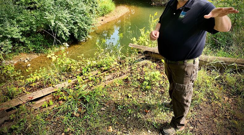 Eric Sauer, planning manager at Five Rivers MetroParks, on Thursday stands next to a channel at Carriage Hill MetroPark in Huber Heights that’s been damaged from erosion because it’s taken on more water than it can handle when ephemerals streams in the area were replaced with retention ponds. He and others are pushing back on HB 175, which is proposing to deregulate ephemeral streams. MARSHALL GORBY\STAFF