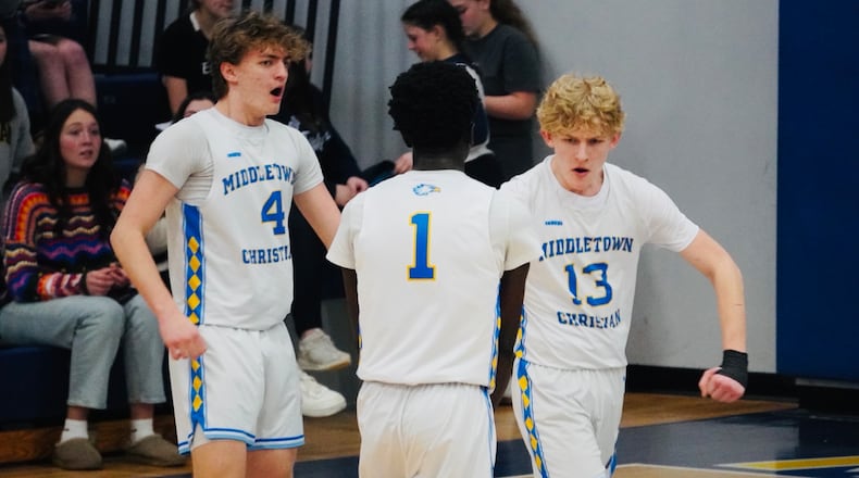 Middletown Christian’s Mason Gross (13) celebrates with teammates Peniel Enninful (1) and Gavin Gross (4) after sinking a 3-pointer against Cincinnati Christian on Tuesday night. Chris Vogt/CONTRIBUTED
